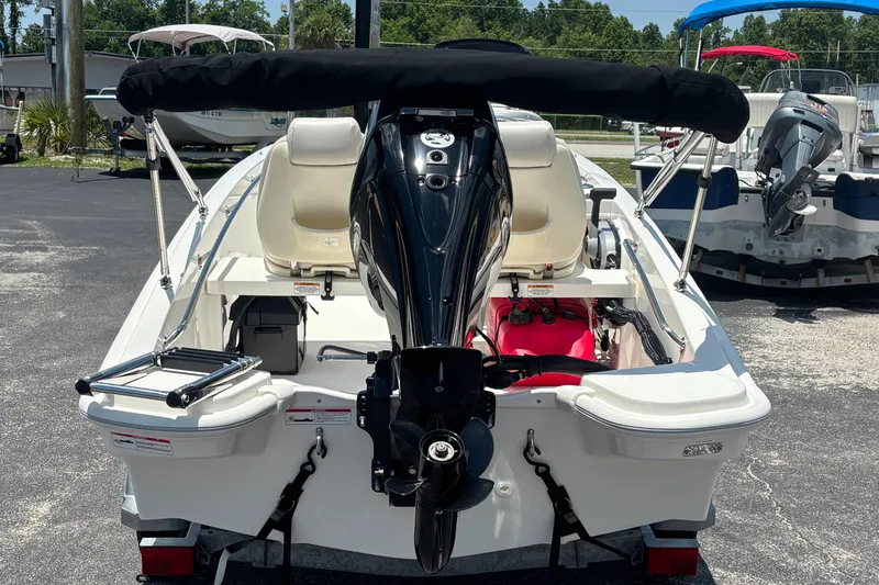 Slide: The Image of 2025 Boston Whaler 130 Super Sport boat, rear view with outboard motor and seating. - 29