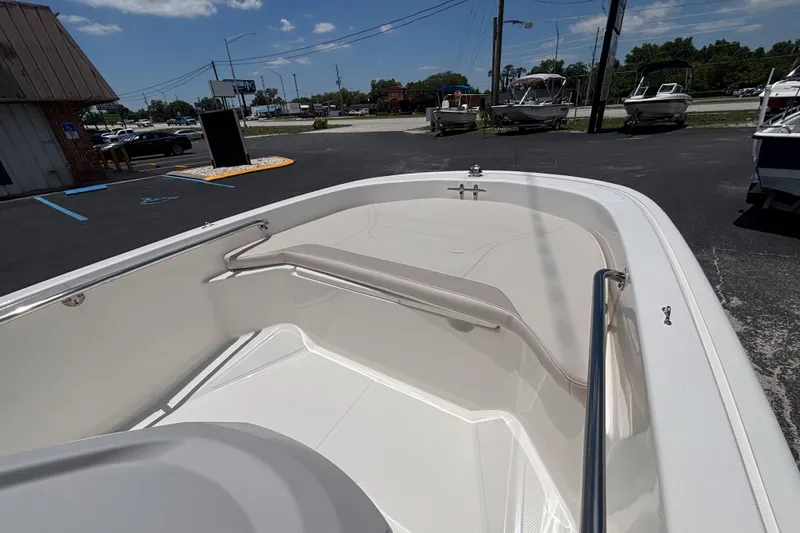 Slide: The Image of 2025 Boston Whaler 130 Super Sport boat interior, showcasing seating and railing under a clear sky. - 30