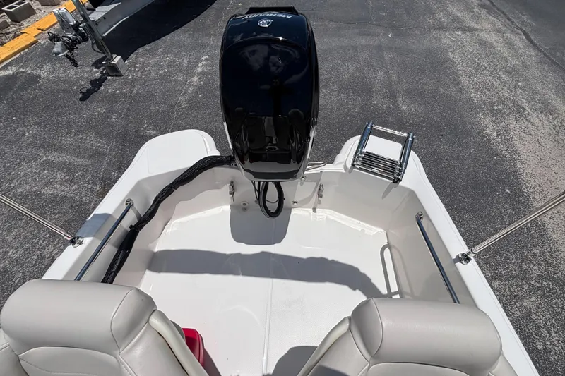 Slide: The Image of 2025 Boston Whaler 130 Super Sport boat interior with motor and seating. - 31