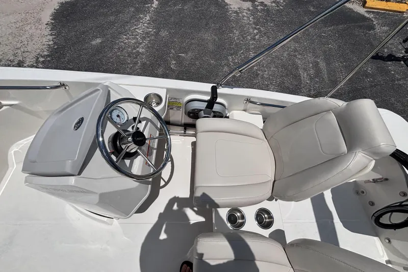 Slide: The Image of 2025 Boston Whaler 130 Super Sport boat interior with steering wheel and seating. - 35