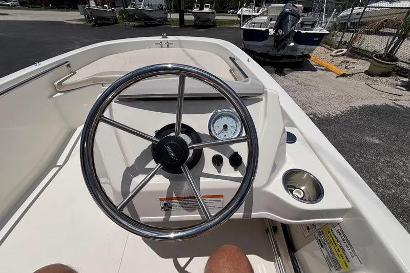 Slide: The Image of 2025 Boston Whaler 130 Super Sport boat dashboard with steering wheel and gauge. - 37