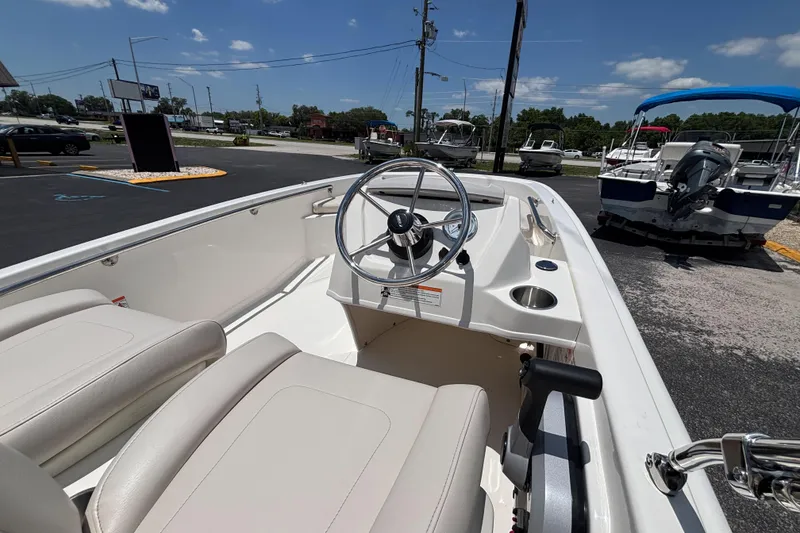 Slide: The Image of 2025 Boston Whaler 130 Super Sport boat interior with steering wheel and seating. - 9