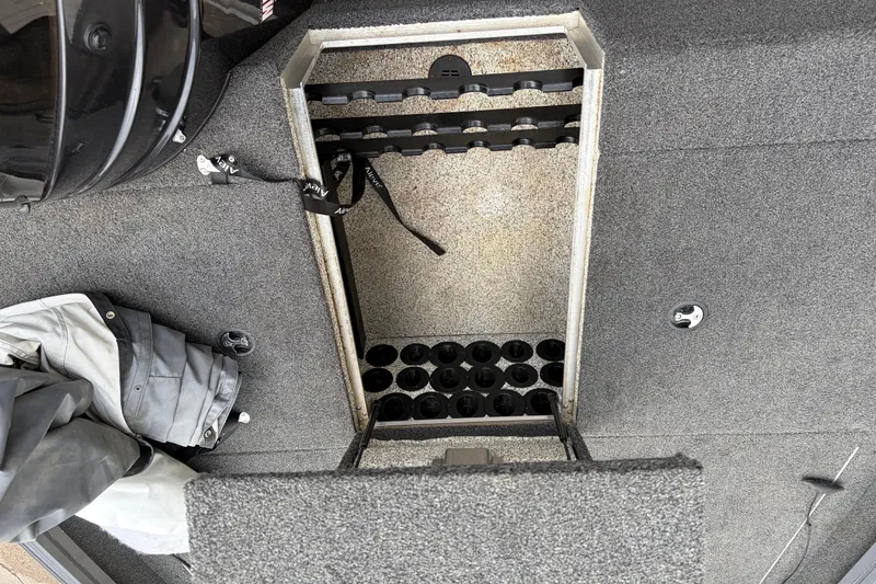 Slide: The Image of Interior view of a 2018 Polarcraft TX 195 boat storage compartment with fishing rod holders. - 26