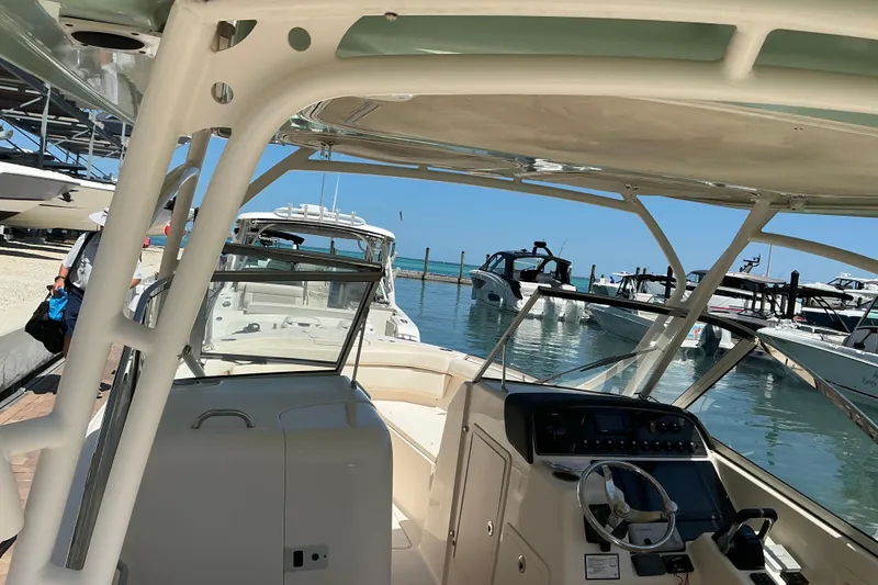 Slide: The Image of 2018 Grady-White Freedom 285 boat docked at marina, showcasing helm and seating area. - 11
