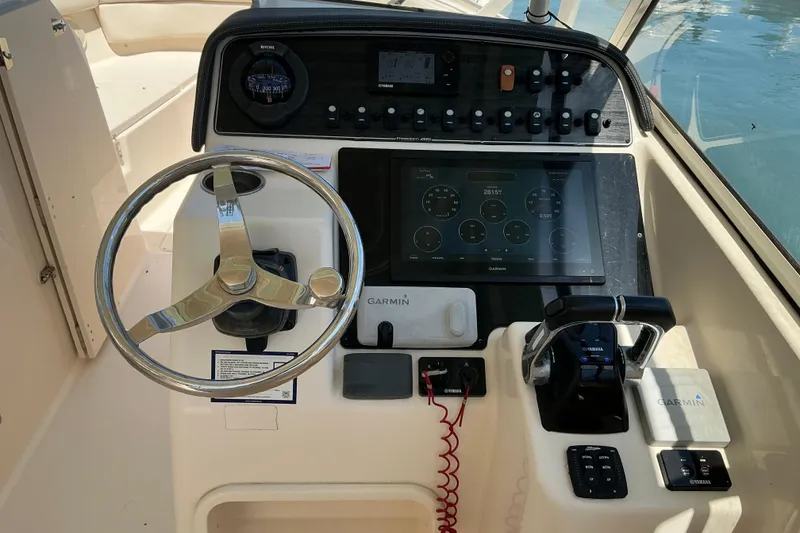 Slide: The Image of Helm of 2018 Grady-White Freedom 285 boat with Garmin navigation system and controls. - 13