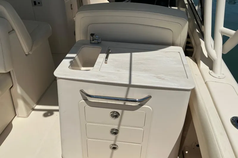 Slide: The Image of 2018 Grady-White Freedom 285 boat interior with sink and storage drawers. - 15