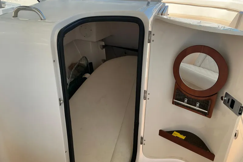 Slide: The Image of 2018 Grady-White Freedom 285 cabin interior with bed and round mirror. - 16