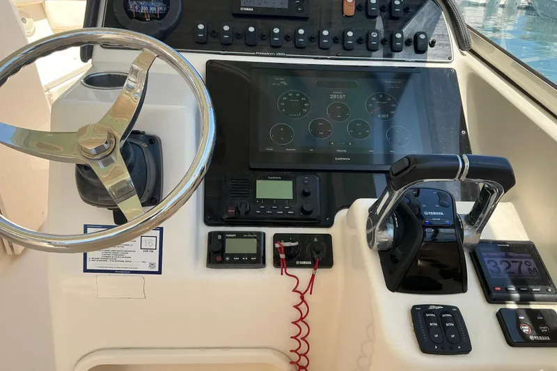 Slide: The Image of Control panel of 2018 Grady-White Freedom 285 boat with steering wheel and Garmin display. - 21