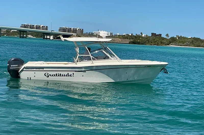 Slide: The Image of 2018 Grady-White Freedom 285 boat named "Gratitude" on turquoise water near a bridge. - 27
