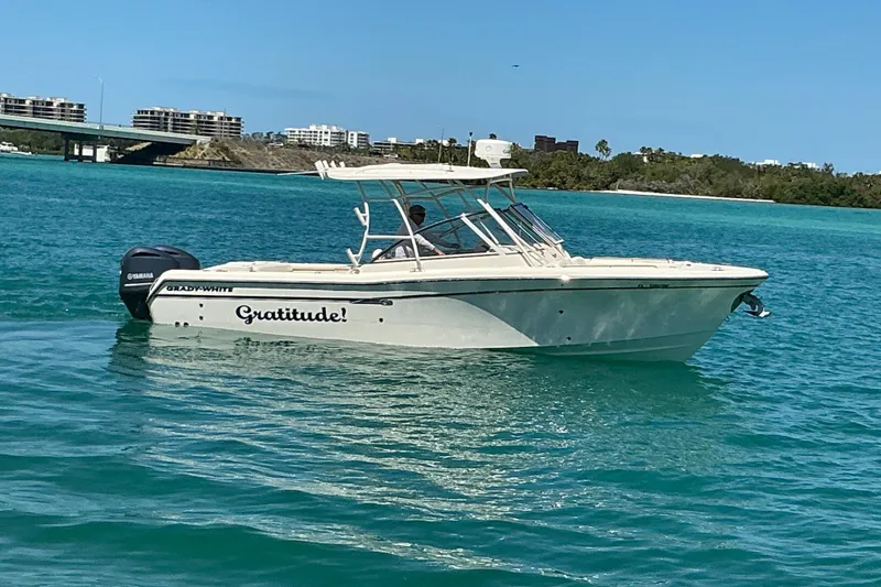 Slide: The Image of 2018 Grady-White Freedom 285 boat named "Gratitude" on turquoise water near a bridge. - 28