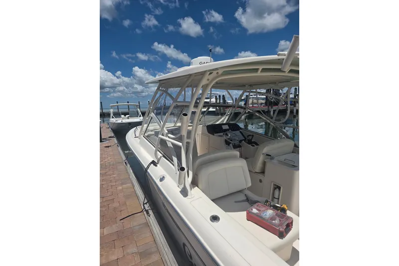 Slide: The Image of 2018 Grady-White Freedom 285 boat docked under a clear blue sky. - 5