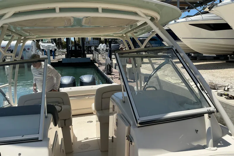 Slide: The Image of 2018 Grady-White Freedom 285 boat docked, featuring dual outboard motors and spacious seating. - 5