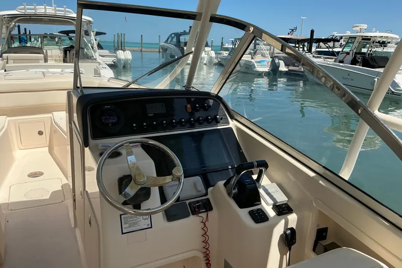 Slide: The Image of 2018 Grady-White Freedom 285 boat cockpit with steering wheel and control panel. - 7