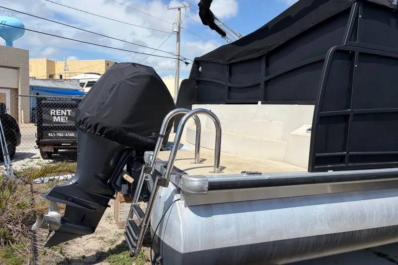 Slide: The Image of 2015 Premier 290 Grand View pontoon boat with covered outboard motor and ladder. - 2