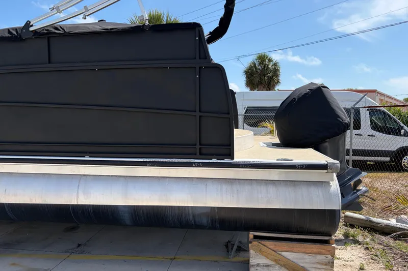 Slide: The Image of 2015 Premier 290 Grand View pontoon boat on blocks, side view with covered motor. - 3