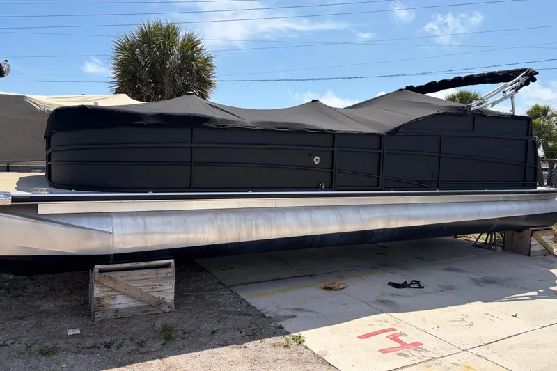 Slide: The Image of 2015 Premier 290 Grand View pontoon boat with black cover, parked outdoors. - 4