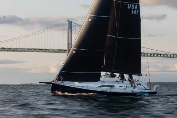 Slide: The Image of 2026 J Boats J/99 sailing near a bridge at sunset. - 2