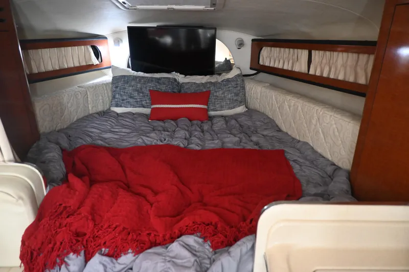Slide: The Image of Cozy cabin interior of 2005 Sea Ray Sundancer 280 with red and gray bedding. - 25