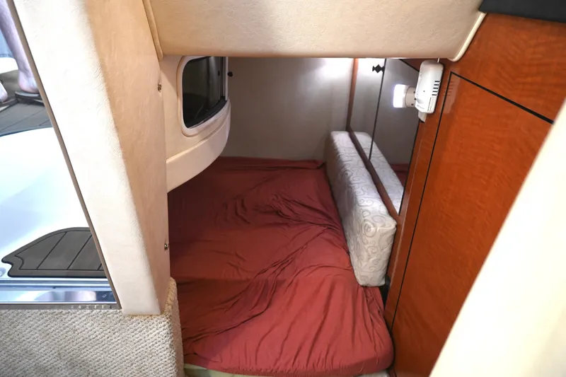 Slide: The Image of 2005 Sea Ray Sundancer 280 cabin interior with red bedding and wooden cabinetry. - 27