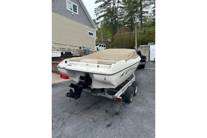 Slide: The Image of 2001 Stingray 200 LS/LX boat on trailer, covered, parked outdoors. - 4