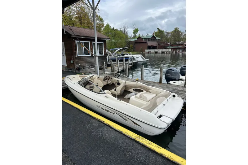 Slide: The Image of 2001 Stingray 200 LS/LX boat docked by a lakeside cabin. - 7