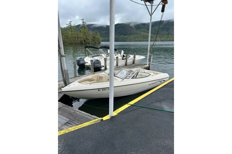 Slide: The Image of 2001 Stingray 200 LS/LX boat docked on a scenic lake with forested hills. - 9