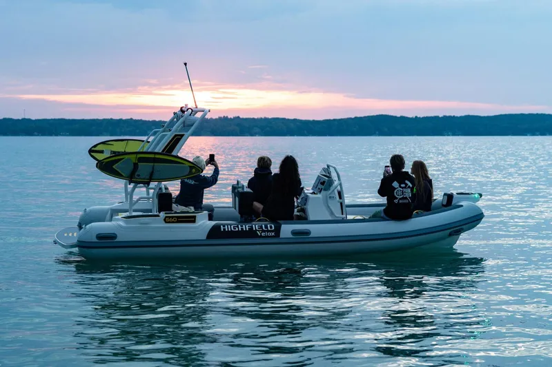 Slide: The Image of Manufacturer Provided Image: Highfield VELOX 560 boat on water at sunset, 2025 model, with passengers enjoying the view. - 2