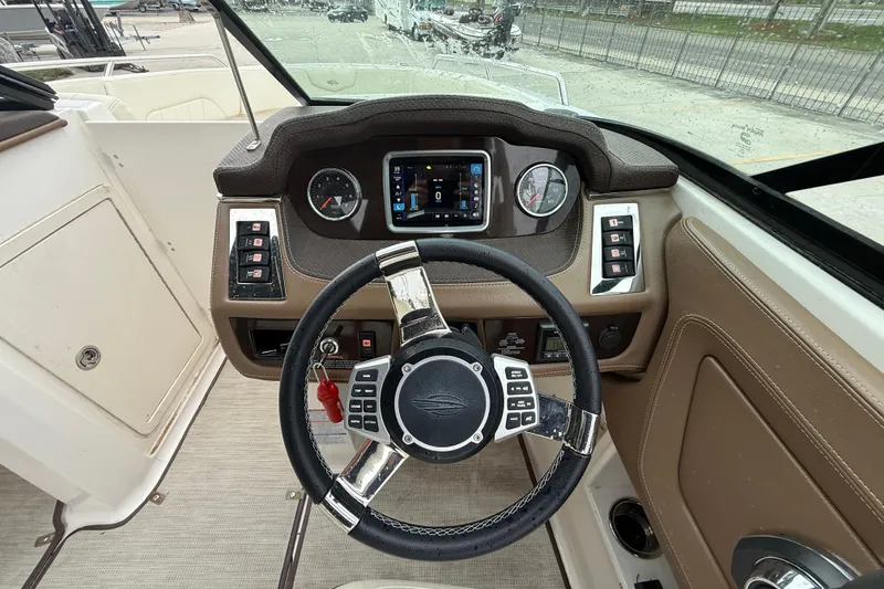 Slide: The Image of 2018 Chaparral 227 SSX Surf boat dashboard with steering wheel and control panel. - 14