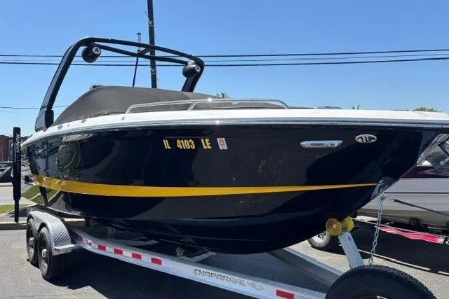 Slide: The Image of 2023 Chaparral 267 SSX boat on trailer, black with yellow stripe, parked outdoors. - 22