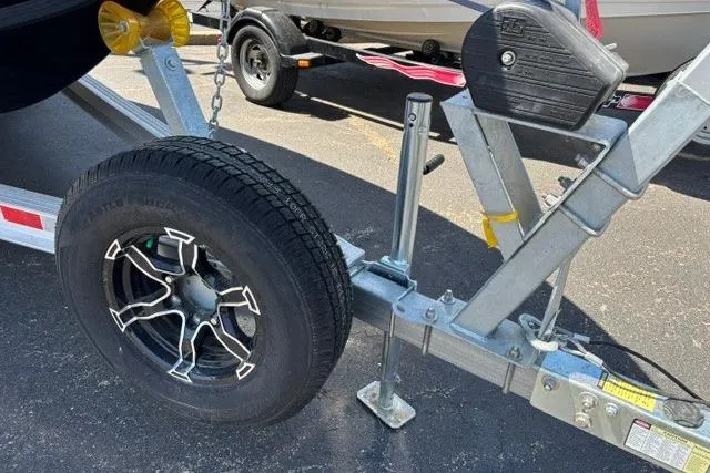 Slide: The Image of Trailer hitch and wheel of 2023 Chaparral 267 SSX boat on asphalt. - 23