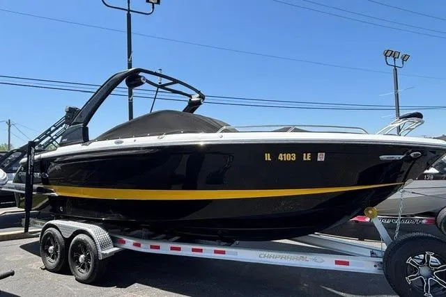Slide: The Image of 2023 Chaparral 267 SSX boat on trailer, black with yellow stripe, parked outdoors. - 24
