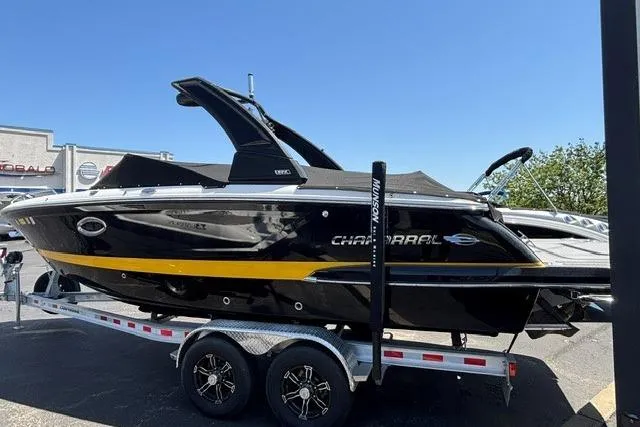 Slide: The Image of 2023 Chaparral 267 SSX boat on trailer, sleek black design with yellow accent. - 26