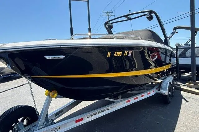 Slide: The Image of 2023 Chaparral 267 SSX boat on trailer, sleek black design with yellow stripe. - 4