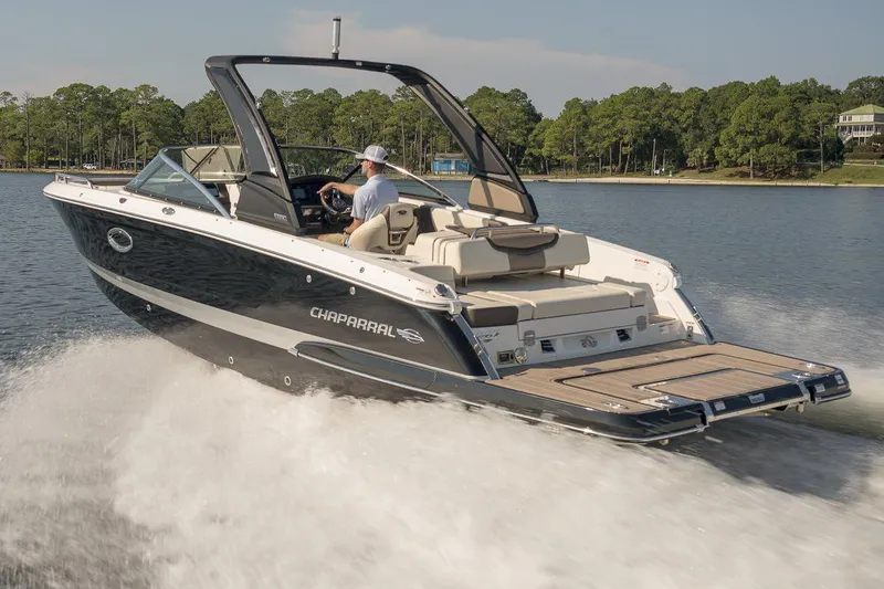 Slide: The Image of Manufacturer Provided Image: 2023 Chaparral 267 SSX speedboat cruising on a lake with lush green trees in the background. - 6