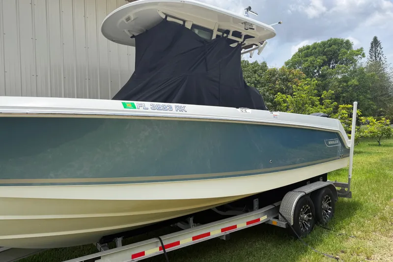 Slide: The Image of 2016 Boston Whaler 250 Outrage boat on trailer, parked outdoors. - 10