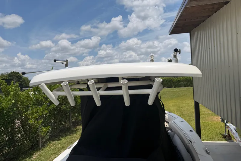 Slide: The Image of 2016 Boston Whaler 250 Outrage boat with rod holders, under a partly cloudy sky. - 17