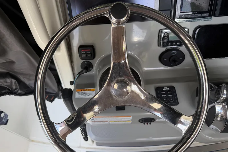 Slide: The Image of Steering wheel of a 2016 Boston Whaler 250 Outrage boat, showcasing dashboard controls. - 19