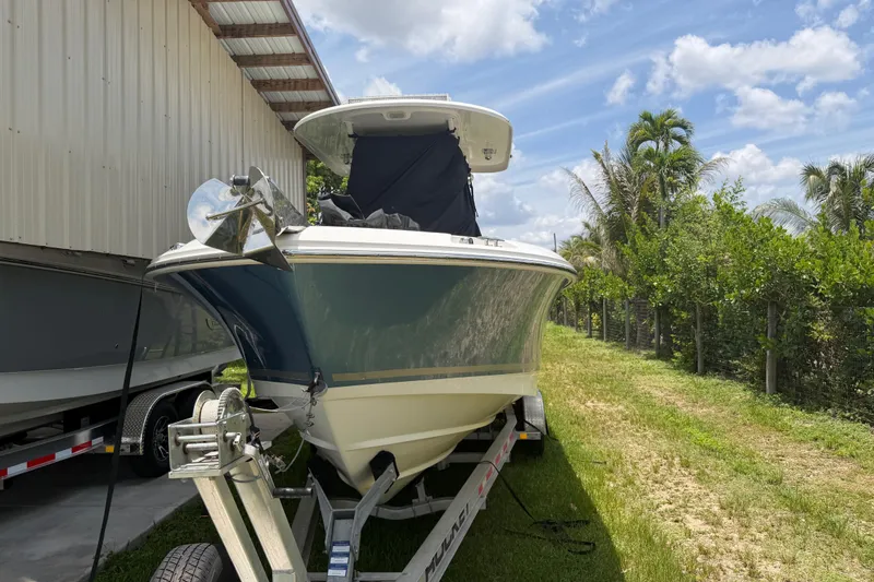 Slide: The Image of 2016 Boston Whaler 250 Outrage boat on trailer, parked outdoors near a building. - 3