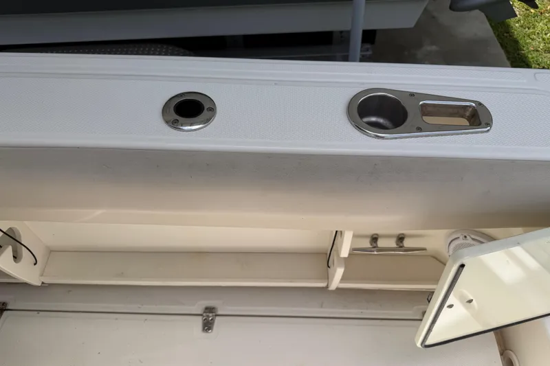 Slide: The Image of 2016 Boston Whaler 250 Outrage boat interior with rod holders and storage compartment. - 30