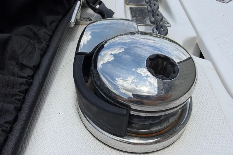 Slide: The Image of Chrome winch on 2016 Boston Whaler 250 Outrage boat deck, reflecting sky and clouds. - 44