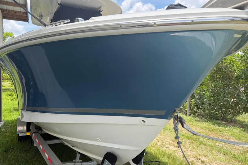 Slide: The Image of 2016 Boston Whaler 250 Outrage boat on trailer, blue hull, sunny day. - 5