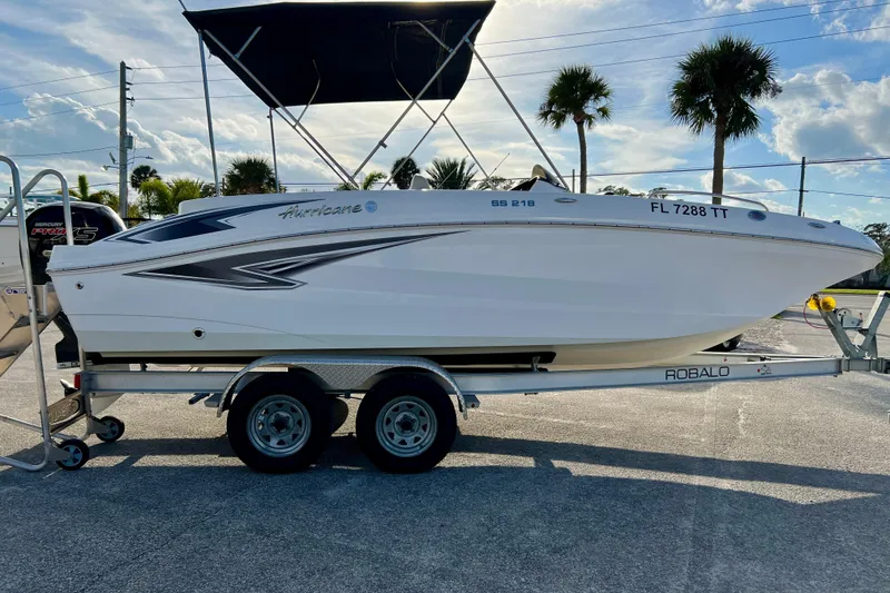 The Image of 2024 Hurricane Sundeck Sport 218 OB boat on trailer, parked outdoors under a clear sky. - 1