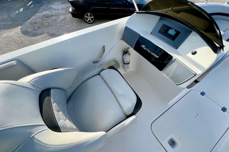 Slide: The Image of 2024 Hurricane Sundeck Sport 218 OB boat cockpit with steering console and cushioned seat. - 10