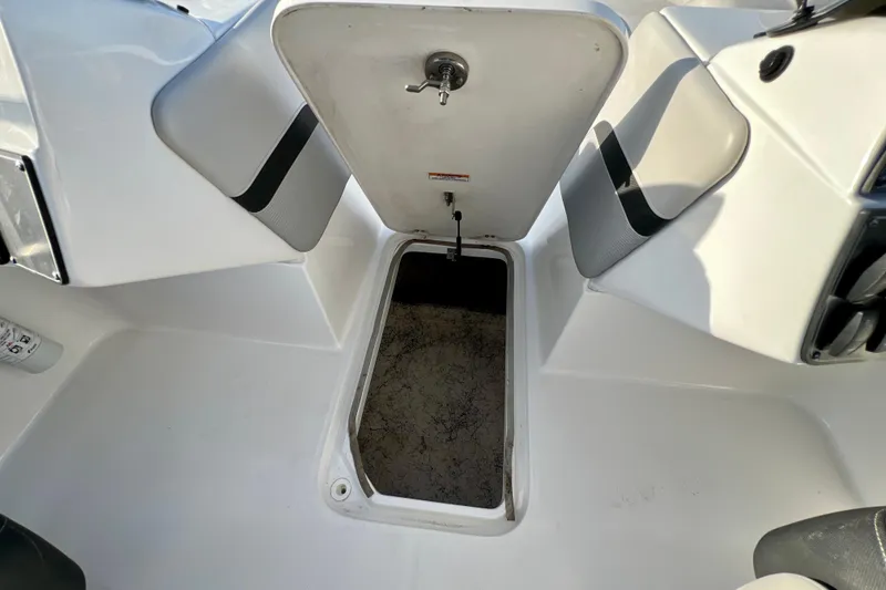 Slide: The Image of 2024 Hurricane Sundeck Sport 218 OB boat storage compartment open, showcasing interior space. - 13