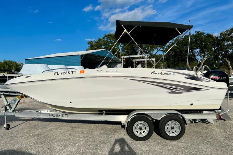 Slide: The Image of 2024 Hurricane Sundeck Sport 218 OB boat on trailer, featuring sleek design and canopy. - 5