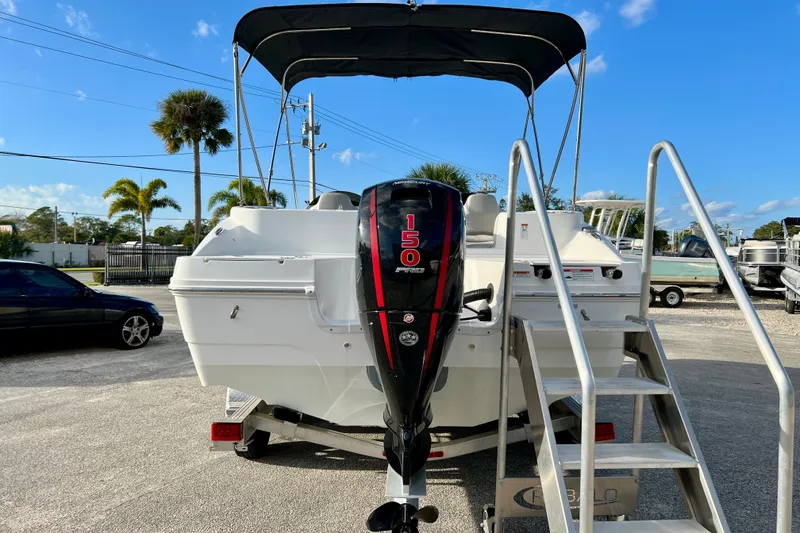 Slide: The Image of 2024 Hurricane Sundeck Sport 218 OB boat with 150 HP engine, parked outdoors. - 7