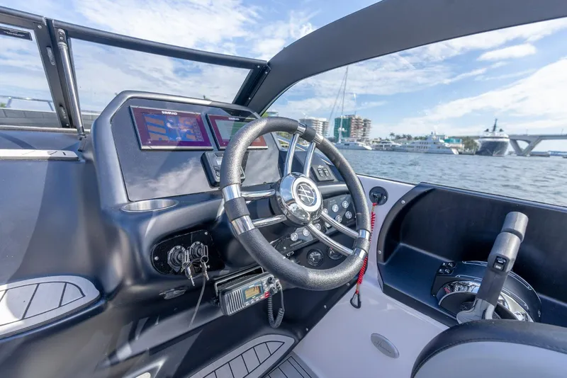 Slide: The Image of Interior view of a 2027 Hanover 305 boat cockpit with modern controls and steering wheel. - 12
