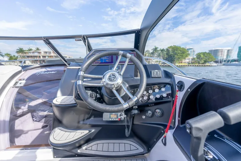 Slide: The Image of Steering console of a 2027 Hanover 305 boat, featuring modern controls and waterfront view. - 13