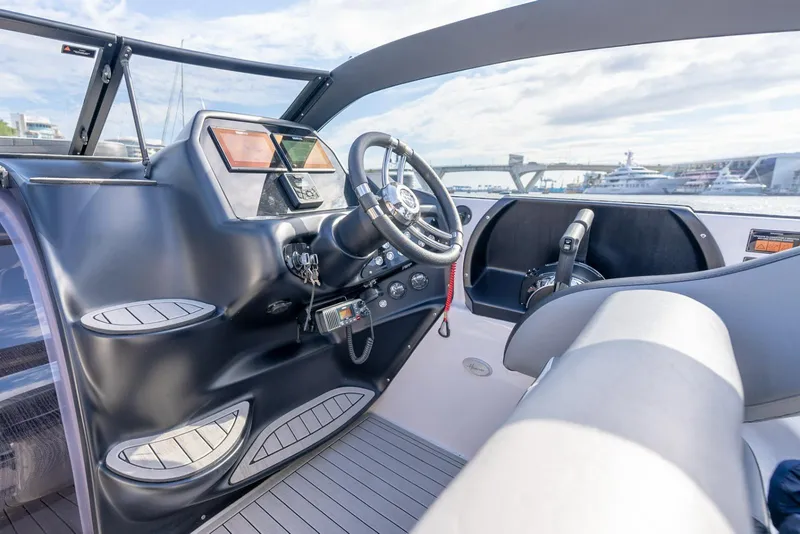 Slide: The Image of Interior view of a 2027 Hanover 305 boat cockpit with modern controls and steering wheel. - 15