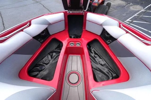 Slide: The Image of 2015 Moomba Mojo boat interior with red and gray seating, cup holders, and storage compartments. - 10